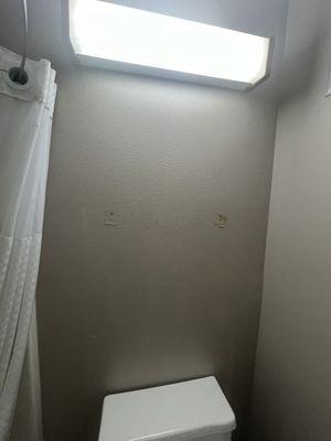 Towel bar removed, hole exposed and unfinished