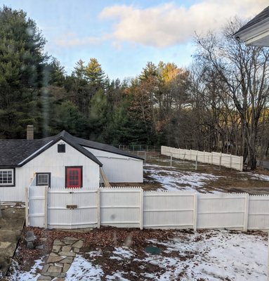 Overview of kennel property, customer entrance, and fenced outdoor dog play yard