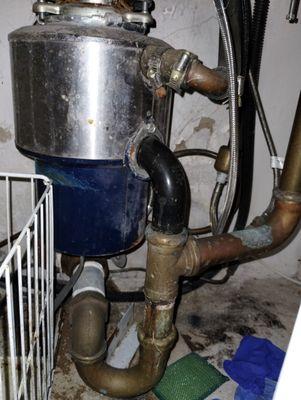 Old and broken garbage disposal with leaking pipes