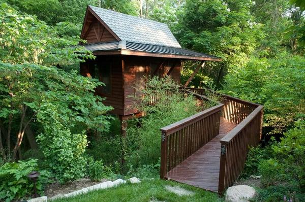 This Thai inspired spirit house is nestled away in the woods. Accessed by a wooden bridge it makes a perfect little getaway.