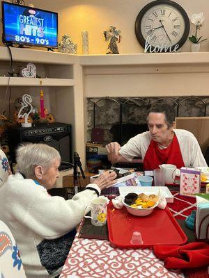 Resident Isabel and Michael sharing a box of sweets.