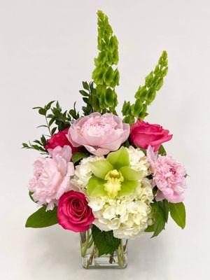 Enchanted | A stunning assortment of hydrangea, orchid, peonies and roses in a beautiful pink, white and green color palette.