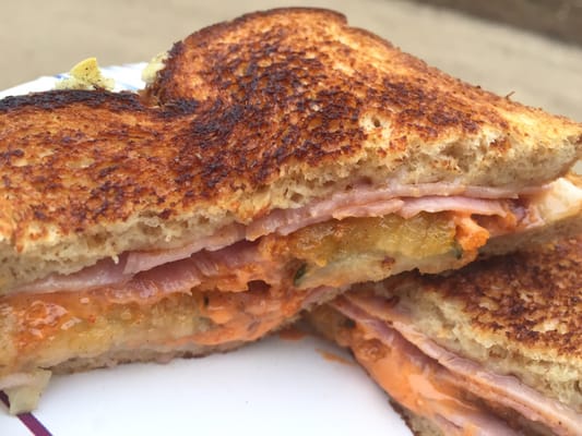 Grilled ham & swiss with fried pickles & spicy aioli on crunchy wheat bread