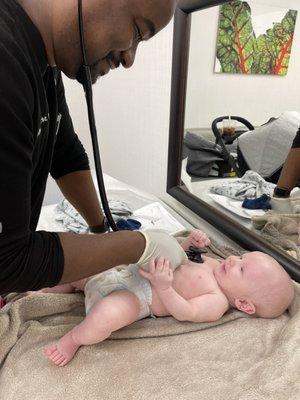 Dr. Clarke giving a well-baby checkup to a happy patient.