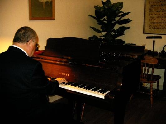 Ronald Thomas playing piano in the studio where he teaches.