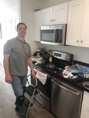 Alex cleaning up after fixing the microwave