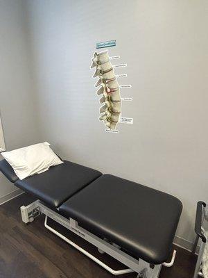 Exam bed with spinal wall diagram at Novant Health Spine Specialists