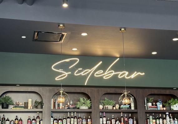 Love the sign above the bar and the stunning wooden arches showcasing the alcohol.