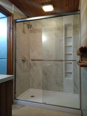 KIRBY low entry walk in shower system with recessed shelving, anti-leak shower base and cremora solid-surface surround