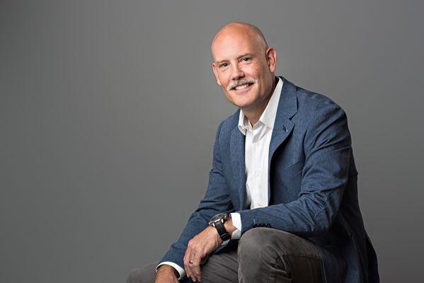 Studio headshot of smiling San Antonio businessman.