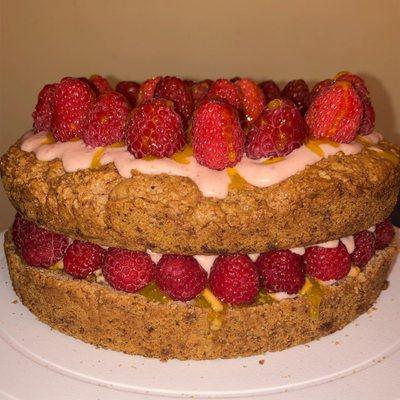 Vegan layered fruit cake with raspberries and vegan lemon curd drizzled on the inside.