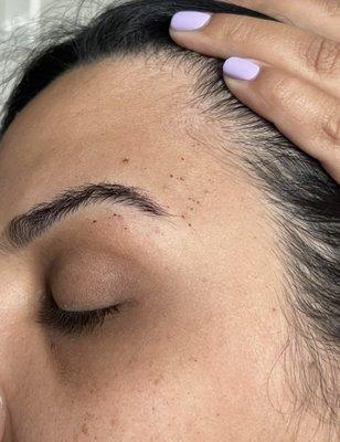 Red spots around my eyebrows is skin she removed while threading. I requested full face and you can see hairs in my face! Dont go here!