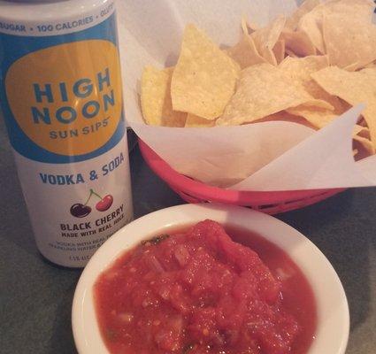 Chips and salsa with hard seltzer while waiting for my family to arrive.