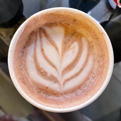 Floral latte art topper on a hot drink.