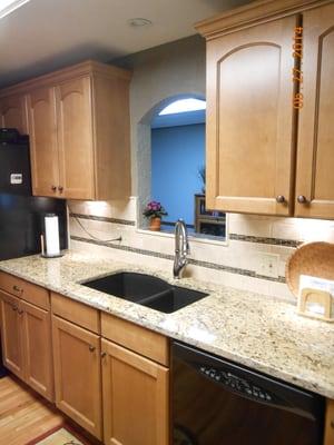 New cabinets, back splash, counter tops, window opening between kitchen and new dining area, sink, faucets; beautiful kitchen