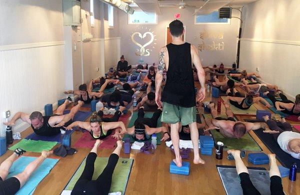 Brandon leads a class through Locust pose