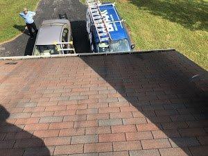 Brax Roofing checking on the wind damage in an asphalt shingle roof in Fairfax neighborhood of Eaves Fairfax City