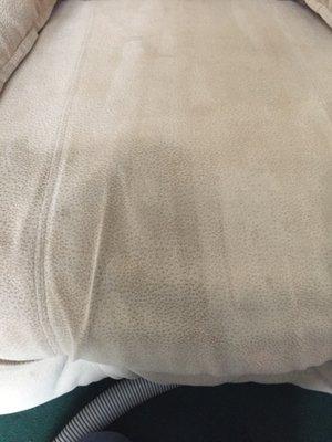 The seat of an upholstered recliner. The seat has been cleaned except the dark corner shown.