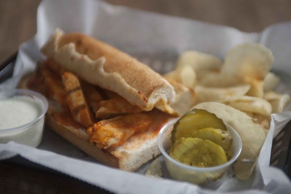 We offer a variety of sandwiches, including a Buffalo Chicken option served with chips, pickles, and ranch or blue cheese.