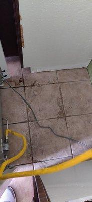 Dirty floor behind stove.