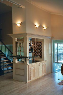 A bar with cabinets and a faucet. Glass shelves.
Maple.