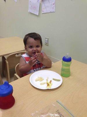 Sitting properly kid sized table and using hands appropriately to feed oneself in a school/ community atmosphere.