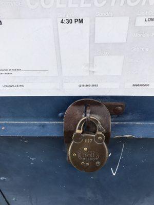 Old school lock on the USPS drop box out side the office