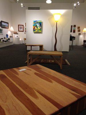 Fiber art, prints, pottery, photos, and paintings create a backdrop for unique furniture and one of a kind lamps.