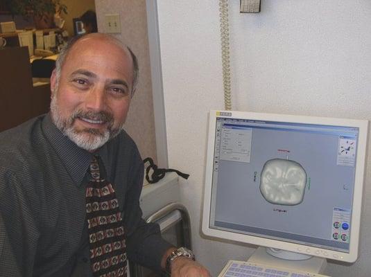 Dr. Pearlstein in front of his Cerec Cad/Cam unit used for fabricating single visit crowns