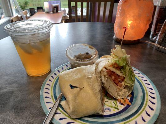 Super veggie wrap with a patty, chocolate chip cookie dough (side) and an iced tea.