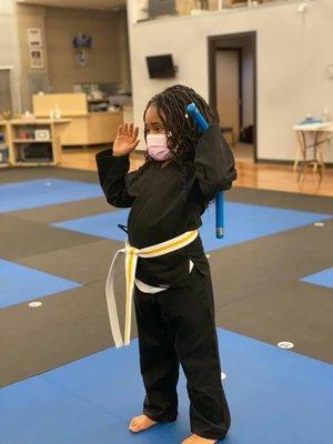 A young student practicing with their nunchuck