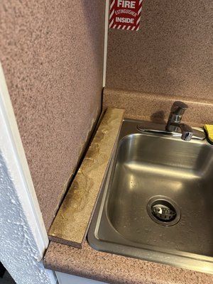 Dirty sink area with broken section