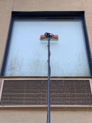 Mildew stained window  clean of hotel using water fed machine.