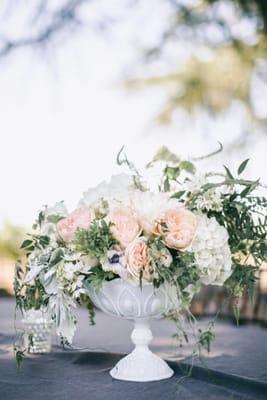 Vintage milk glass compote of flowers in assymetrical design. Modern meets vintage wedding reception.