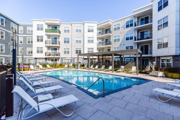 Pool with lounge chairs and view of apartments