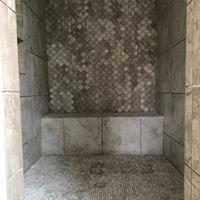 A walk-in master shower in 18x18 with a marble mosaic accent wall