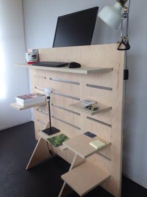 Full-sized standing desk with shelving, also available on wheels.