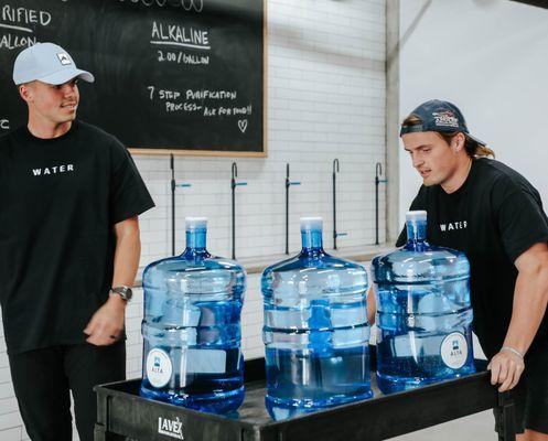 Employees help customers take bottles to car.