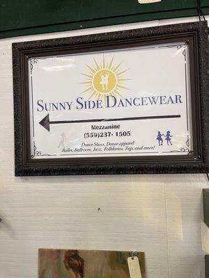 The sign at the landing on the staircase, one of the only indicators that the dance store is upstairs.