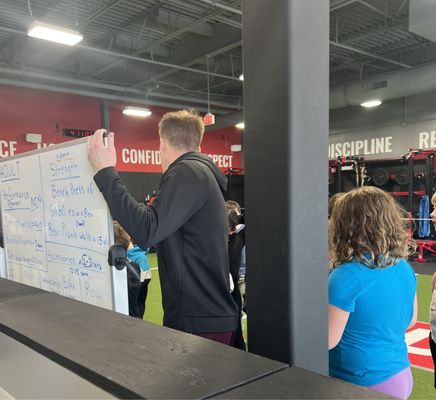 Coach Martin explains the circuit for the day to the kids.