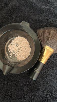 Setting powder is applied to lock in your tan