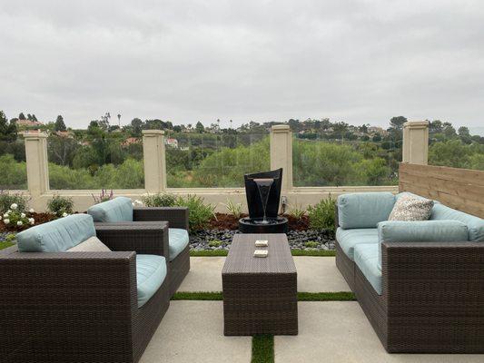 An outdoor living space with fountain, designed by Landscape Logic