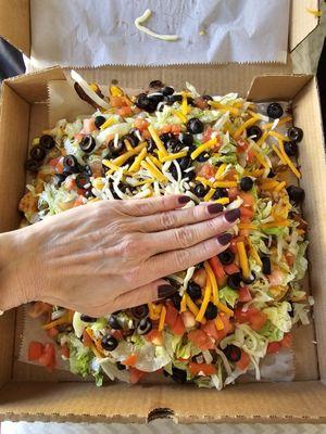 Put my hand in the picture just to show scale this is an entire pizza box filled with nachos.