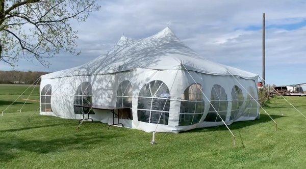 Tent, siding, and heater rented with tables and chairs inside.