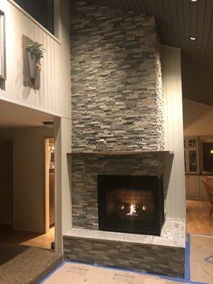 Gas fireplace with granite hearth and walnut mantle.