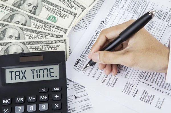 An overview of three 1040 income tax forms, stacked neatly on top of each other, representing the variety of tax filers in the community.