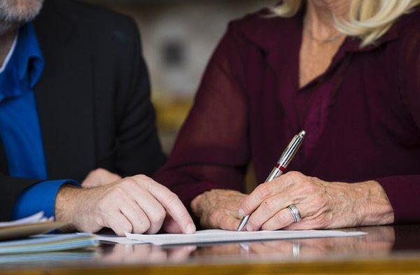 Two people signing documents