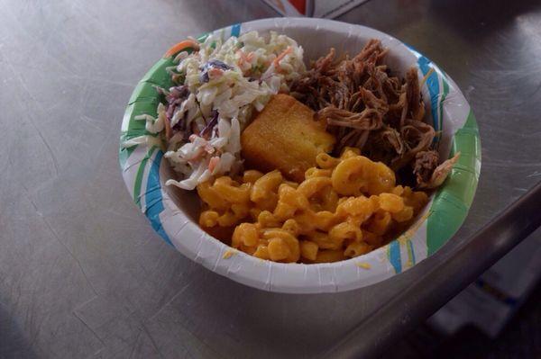 Bowl Of ' Que - smoked pulled pork, Cole slaw, mac n cheese, surrounding a piece of cornbread served in a 20 ounce bowl