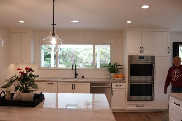 White subway tiles & cabinetry give this kitchen remodel in Villa Park a clean, modern look and emphasize the stunning view.