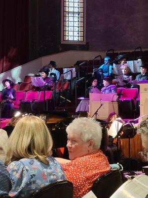 Seated view of performers waiting to enter stage area.